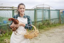 Woman on chicken farm holding chicken in hands — Stock Photo