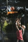 Young male basketball players throwing ball at basketball hoop — Stock Photo