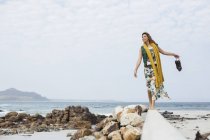 Young woman walking on cement block on beach, Cape Town, Western Cape, South Africa — Stock Photo