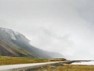 Nube baja en la ladera de la montaña, Hof, Islandia - foto de stock