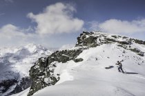 Esquiador masculino adulto medio caminando a la cima de la montaña con esquís, Corvatsch, Suiza - foto de stock