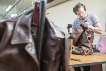 Homem trabalhando em fabricantes de jaquetas de couro — Fotografia de Stock