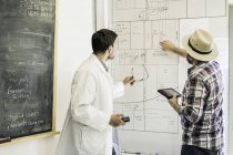 Scientists planning on whiteboard in plant growth research facility laboratory — Stock Photo
