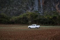 Voiture blanche rétro dans le paysage rural par montagne — Photo de stock