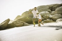 Père et fils jouant au football sur la plage — Photo de stock