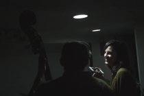 Музыканты с контрабасом и смартфоном в музыкальной студии — стоковое фото