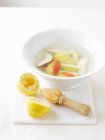 Cuenco de agua con jugo de limón para prevenir las verduras - foto de stock