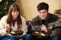 Paar isst Abendessen mit Mikrowelle auf dem Sofa — Stockfoto