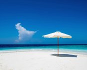 Paraguas en la playa de arena blanca, Maldivas - foto de stock
