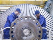 Male engineers repairing steam turbine in workshop — Stock Photo