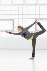 Giovane donna in piedi in posa yoga — Foto stock