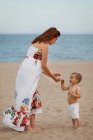 Mãe e criança de pé na praia — Fotografia de Stock