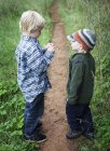 Brothers standing together on garden path outdoors — Stock Photo