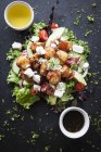 Top view of meat and feta salad with dipping sauces on slate — Stock Photo