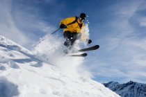 Male skiing over mountain ridge — Stock Photo