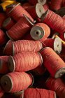 Primer plano de bobinas de hilo rojo pila - foto de stock