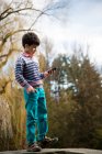 Junge spielt auf Spielplatz mit Smartphone — Stockfoto