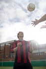 Zwei junge Männer spielen mit Fußball auf städtischem Fußballplatz — Stockfoto