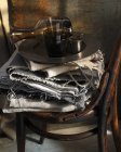 Стаканы и графин на тканях и винтажном стуле — стоковое фото