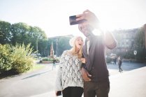 Пара делает селфи со смартфоном в парке — стоковое фото