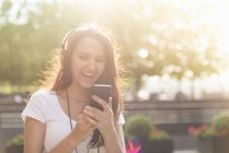 Молода жінка в навушниках слухати музику — стокове фото