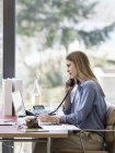 Junge Geschäftsfrau telefoniert am heimischen Schreibtisch — Stockfoto