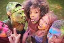 Portrait of group of friends at festival, covered in colourful powder paint — Stock Photo