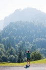 Вид сзади на человека, смотрящего на покрытые деревьями горы, Пассо Фава, Италия — стоковое фото