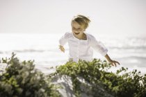 Мальчик бежит по пляжу, смеется — стоковое фото