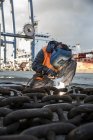 Dock welder welding chain on waterfront — Stock Photo