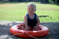 Мальчик, сидящий в спасательном жилете — стоковое фото
