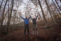 Hikers throwing leaves in woods, Montseny, Barcelona, Catalonia, Spain — Stock Photo
