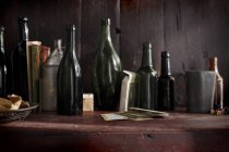 Close up shot of pile of emty wine bottles on wooden table — Stock Photo