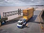 Vista elevata di camion e container di spedizione su rampa di nave — Foto stock