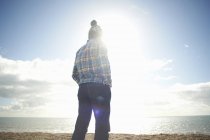Mature man looking out to sea from beach — Stock Photo