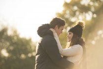 Casal jovem sorrindo cara a cara no ambiente rural — Fotografia de Stock