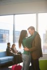 Young couple hugging in airport — Stock Photo
