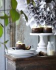 Mini christmas puddings on cakestand and plates on patio table — Stock Photo