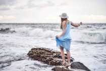 Woman enjoying walk on rocks in sea — Stock Photo