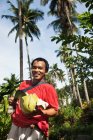 Человек держит срезанные тропические фрукты — стоковое фото