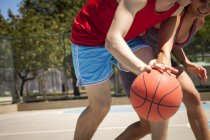 Jovem casal praticando basquete na quadra — Fotografia de Stock