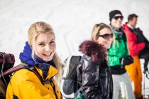 Junge Frau trägt Skikleidung mit Freunden im Hintergrund — Stockfoto