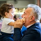 Hombre mayor cara a cara con el nieto bebé en la cafetería - foto de stock