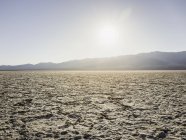 Flat dry mud landscape in Death Valley in sunlight — Stock Photo