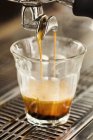 Close-up da máquina de café derramando café em vidro — Fotografia de Stock