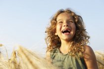 Chica sonriendo en un campo de trigo - foto de stock