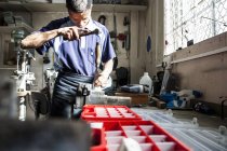 Молодий чоловік використовує молоток і стамеску в ремонтному майстерні — стокове фото