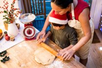 Mãe e filho fazendo biscoitos de Natal em casa — Fotografia de Stock