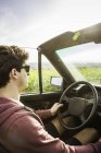 Young man leaning driving convertible — Stock Photo