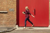 Woman walking past red door, Londres, Reino Unido — Fotografia de Stock